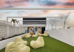 a rendering of a living room with chairs and grass at Rambla at South City SQ in Brisbane