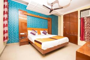 a bedroom with a bed and a blue wall at HOTEL DARPAN INTERNATIONAL -New Delhi Railway Station in New Delhi