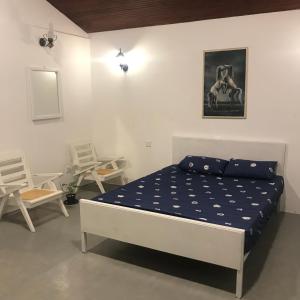 1 dormitorio con 1 cama y 2 sillas en Miracle Trail Kandy en Kandy