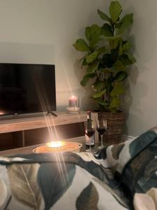 uma mesa com uma vela e dois copos de vinho em Two on Milner - ARUM COTTAGE - Stylish open-plan Guesthouse in Rondebosch na Cidade do Cabo
