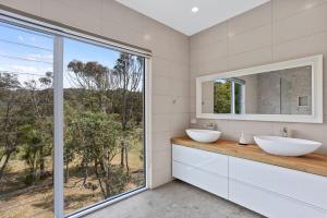 伯马吉Cuttagee Views Luxury ocean beach front Bermagui Linen & Wifi Provided的带两个水槽和大窗户的浴室 更多16张照片
