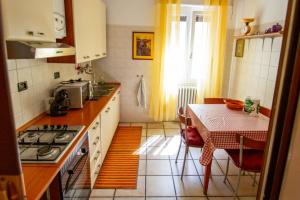 una cucina con un tavolo e una stufa forno superiore di LA DIMORA DEGLI ELFI casa vacanza a Pavia