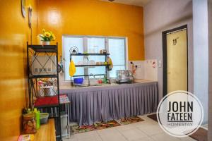 a kitchen with yellow walls and a counter top at lumut manjung homestay john faten in Lumut