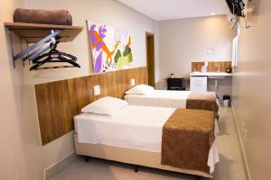 ein Krankenhauszimmer mit 2 Betten und einem Spiegel in der Unterkunft Fiori Suítes in Goiânia