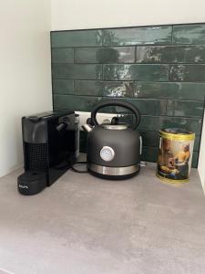 a tea kettle sitting next to a coffee maker and a microwave at Op de Veluwe - met prachtig uitzicht in Nunspeet