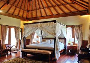 a bedroom with a bed with a canopy at Bagus Jati Health & Wellbeing Retreat in Tegalalang