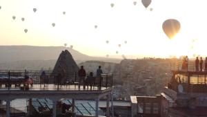 een groep heteluchtballonnen die over een stad vliegen bij Salkım Cave House in Goreme