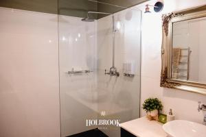 y baño con ducha, lavabo y espejo. en Holbrook Hotel en Holbrook