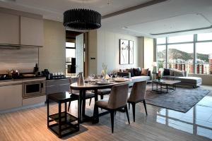 Il comprend une cuisine et un salon avec une table et des chaises. dans l'établissement Hilton Jinan South Hotel & Residences, à Jinan