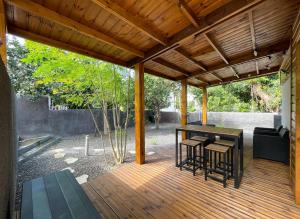 a wooden pergola with a table and chairs on a deck at La Chrysalide du Bassin - DODOTERLA in Saint-Joseph