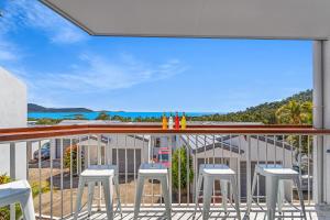 a balcony with stools and a view of the ocean at The View in Cannonvale