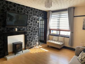 a living room with a fireplace and a tv at 2 Bed Apt - P&J Live, AWPR, Airport in Aberdeen
