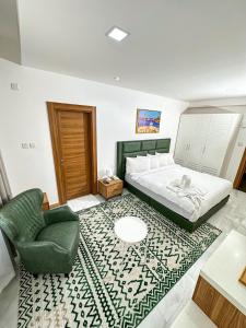 a bedroom with a bed and a green chair at Hotel Sand View in Bawshar