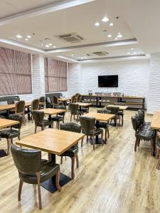 a classroom with tables and chairs and a flat screen tv at Hotel Sand View in Bawshar