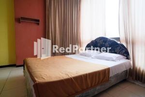 En eller flere senge i et værelse på RedDoorz at Sparkling Hotel Surabaya