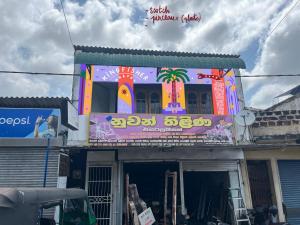 a building with a colorful sign on the side of it at Kingfisher Hostel in Anuradhapura
