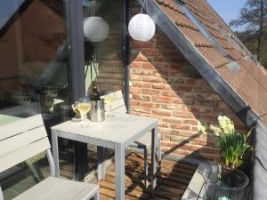 a white table with two glasses of wine on a patio at Storchennest am Dümmer in Lembruch