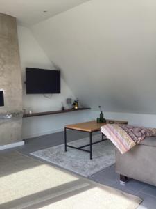 a living room with a table and a tv on the wall at Storchennest am Dümmer in Lembruch