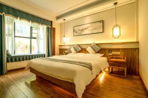Un dormitorio con una cama grande y una ventana en 张家界惹莲心栖墅·精品民宿 en Zhangjiajie