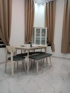 a wooden table and two chairs and a table with curtains at Homestay Asam Pedas Parit Jawa Muar in Bakar Parit
