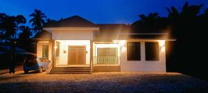 Bakar Parit的住宿－Homestay Asam Pedas Parit Jawa Muar，夜晚在房子前面停车的房屋