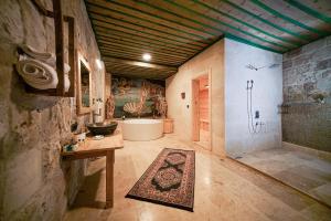 a large bathroom with a bath tub and a rug at Serene Premium Stone House in Nevsehir