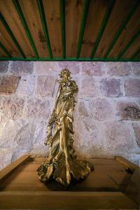 a gold statue of a woman standing next to a brick wall at Serene Premium Stone House in Nevsehir