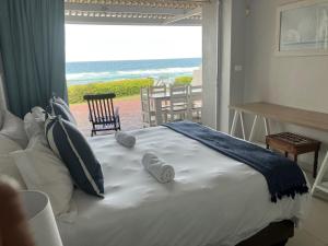a bedroom with a bed and a view of the ocean at 2 Buxtehude in Ballito