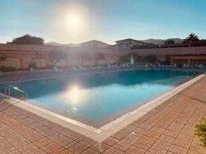 a large swimming pool with chairs in a courtyard at MEDUSA apartment Baja Sardinia in Cala Bitta