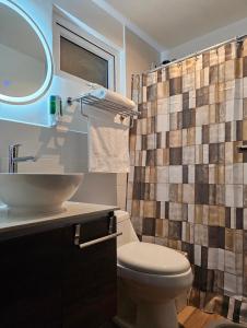 a bathroom with a toilet and a shower curtain at Torre Pamplona 402 -Nuevo y Cómodo- Apartamento in Guatemala