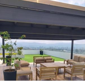 a patio with tables and chairs and a view of the water at Torre Pamplona 402 -Nuevo y Cómodo- Apartamento in Guatemala