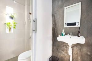 a bathroom with a sink and a toilet and a mirror at Teras Sabin in Ngabean