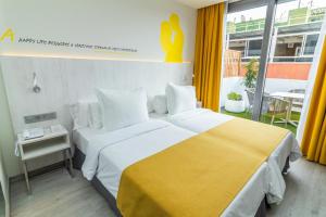 a hotel room with a large bed with a yellow blanket at Lemon & Soul Las Palmas in Las Palmas de Gran Canaria