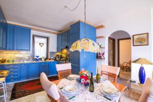 una cocina con armarios azules y una mesa con sillas en Veranda di Menaggio, en Menaggio