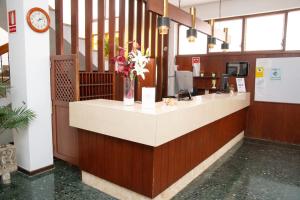 a lobby with a counter with flowers in a vase at Hotel Galera in San Antonio