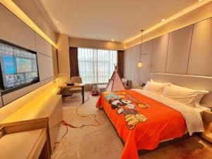 a bedroom with a large bed and a flat screen tv at Qingyuan Argyle Hotel in Qingyuan