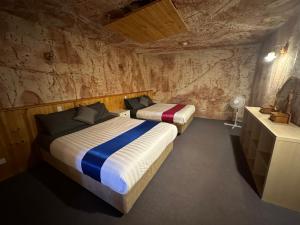 two beds in a room in a cave at Comfort Inn Coober Pedy Experience in Coober Pedy