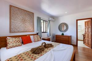 a bedroom with two beds and a mirror on the wall at Cote Mer villa in Baie Sainte Anne