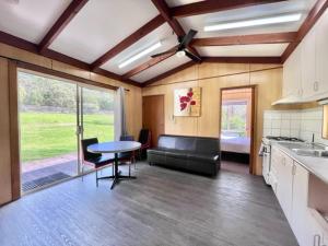 cocina y sala de estar con mesa y sofá en The Grampians Motel, en Halls Gap