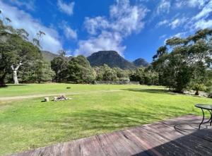 a picnic table in a field with mountains in the background at The Grampians Motel in Halls Gap