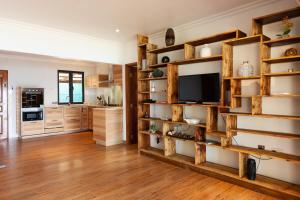 a living room with wooden shelves and a tv at Cote Mer villa in Baie Sainte Anne