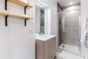 uma casa de banho com um lavatório e um chuveiro em Gîte le 11 em Le Merlerault