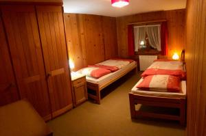 a small room with two beds and a window at Haushälfte Ober Misanenga in Obersaxen