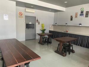 - deux tables et chaises dans un restaurant avec comptoir dans l'établissement OYO 90849 Hotel Hanarilla, à Kampong Batu Tiga