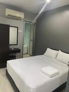 - une chambre avec un lit blanc et un miroir dans l'établissement OYO 90849 Hotel Hanarilla, à Kampong Batu Tiga