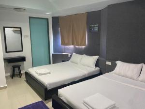 Cette chambre comprend 2 lits et un miroir. dans l'établissement OYO 90849 Hotel Hanarilla, à Kampong Batu Tiga