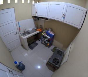 einen Blick über eine kleine Küche mit weißen Schränken in der Unterkunft Terban Garden Homestay Jogja in Jetis + 9 Fotos