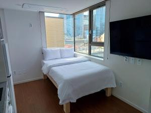 a small bedroom with a bed and a flat screen tv at 318 Stay in Seoul