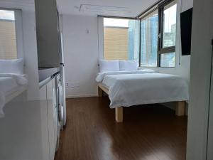 een kleine kamer met 2 bedden en een raam bij 318 Stay in Seoul