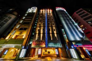 広島市にあるHOTEL LITZ HIROSHIMA -Adult Onlyの夜の都市の高層ビル2棟